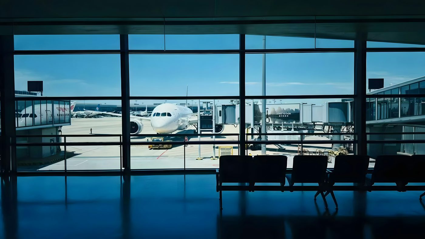 Airport terminal window looking out at a departing plane